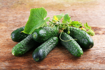 Cucumbers with leafs on wooden background