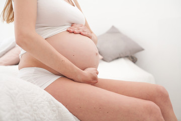 Fototapeta na wymiar Profile of pregnant woman on bed