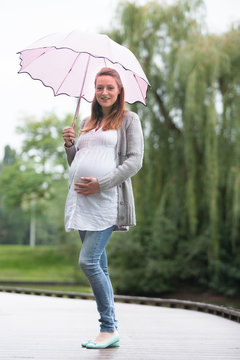 Pregant woman outside with umbrella