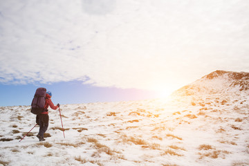 The girl goes through the snow in the mountains.