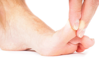 Male person pulling big toe backwards isolated towards white