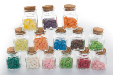 Clear glass jar of candy and colorful jelly beans spilled from jar