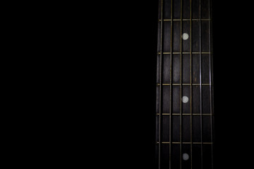 guitar neck isolated on black background, horizontal view, low key image