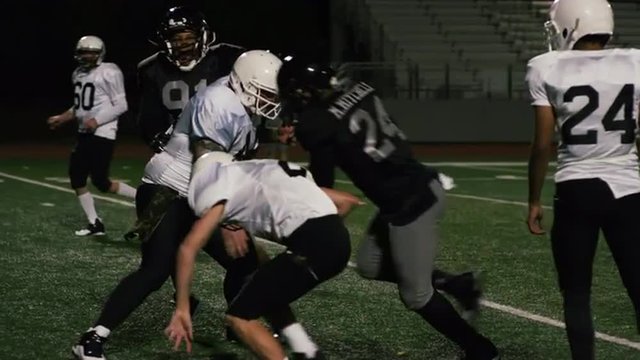A football player pushes his way past his opponents and makes a touchdown