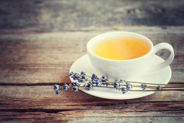 Tea cup and dry lavender flowers on table. Selective focus.