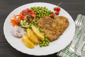 Steak with potatoes, cherry tomatoes and peas on plate