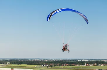 Photo sur Plexiglas Sports aériens aerial view of paramotor flying over the fields