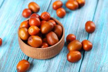 Ripe jujubes on blue wooden table, close up