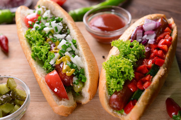 Hot dogs and vegetables on wooden cutting board
