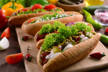 Hot dogs and vegetables on wooden cutting board