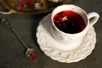 Obraz na płótnie Canvas Cup of rose tea with sugar on wooden table