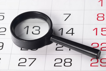 Black magnifying glass over calendar