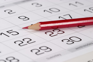 Red pencil over calendar