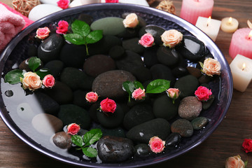 Spa composition of candles, flowers and stones in water, close-up