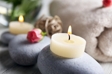 Composition of flowers, candles and stones, in spa salon, close-up