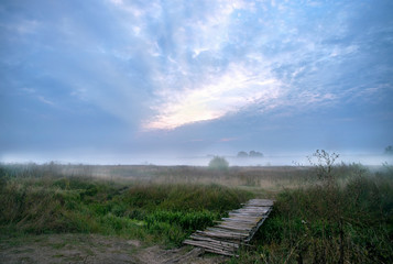 Obraz premium beautiful, misty sunrise on a field near the village