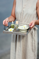 Female hands with tray of spa products, outdoors