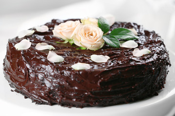 Chocolate cake decorated with flowers on the table, close-up