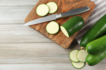 Fototapeta na wymiar Fresh sliced zucchini on cutting board, on wooden background