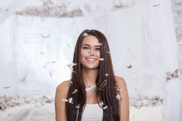 Fototapeta premium woman smiling through flying feathers