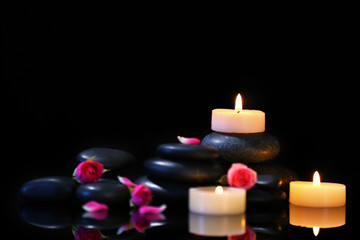 Spa stones and candles on dark background