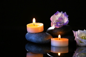 Fototapeta na wymiar Spa stones and candles on dark background