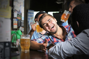 Young men drinking beer in pub