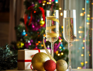 glasses of champagne with christmas present and christmas balls