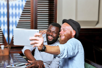 Young men taking photo of themselves in cafe