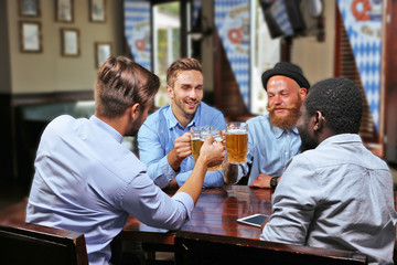 Young men drinking beer and talking in cafe