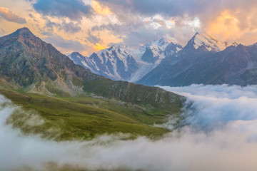 Fototapeta na wymiar Sunset over cloudy walley at Caucasus mountains
