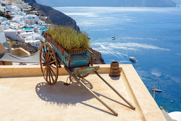 Decorative old cart with flowers on a roof terrace in Oia, Santorini, Greece