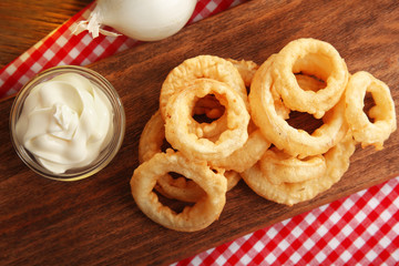Chips rings with sauce and onion on cutting board closeup