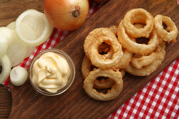 Chips rings with sauce and onion on cutting board closeup