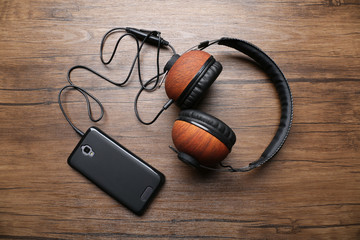 Headphones and smartphone on brown wooden background
