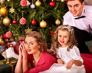 Family with children  dressing Christmas tree.