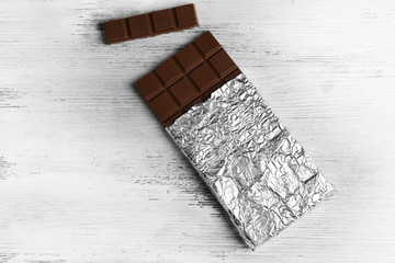 Dark Chocolate bar in foil  on gray background