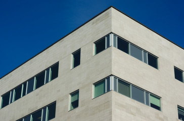 Obraz premium apartment building wall detail and windows on blue sky