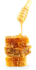 Honey dripping on honeycombs isolated on white