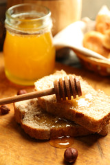 Fresh bread with honey on wooden background