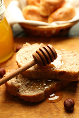 Fresh bread with honey on wooden background