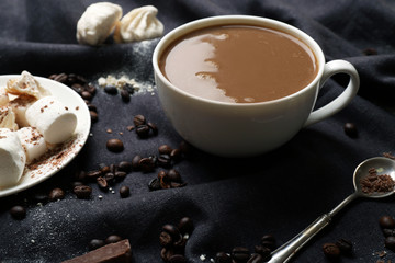 Cup of coffee with sweets on a black tablecloth