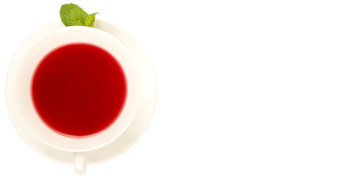 A cup of hibiscus tea and fresh mint leaves over white background