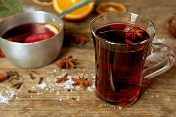 Christmas composition of mulled wine, cinnamon and stew-pan on wooden table