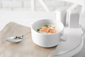 Delicious salmon cream soup on white served table in the restaurant