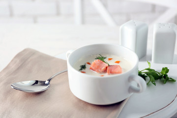 Delicious salmon cream soup on white served table in the restaurant