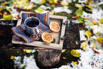 Tray with mug of mulled wine on Old wooden bench in mountains