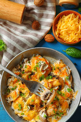 Roasted mushrooms, chicken and cheese gratin in pan, on color wooden background