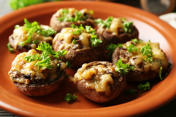 Stuffed mushrooms on plate, on table background