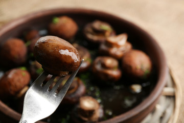 Baked champignons mushrooms with butter, parsley and roasted garlic in brown bowl